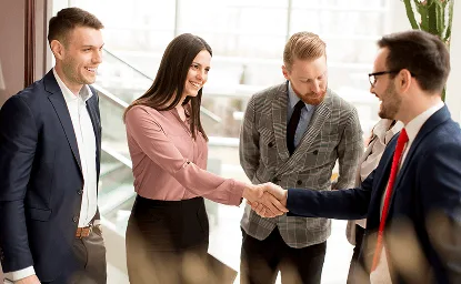 business-partners-handshaking-after-making-agreement-with-employees-near-by 1