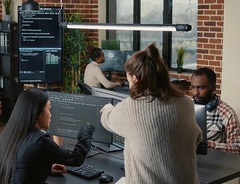 software-programer-pointing-pencil-source-code-computer-screen-explaining-algorithm-coworker-standing-desk-programmers-discussing-online-cloud-computing-with-team-1